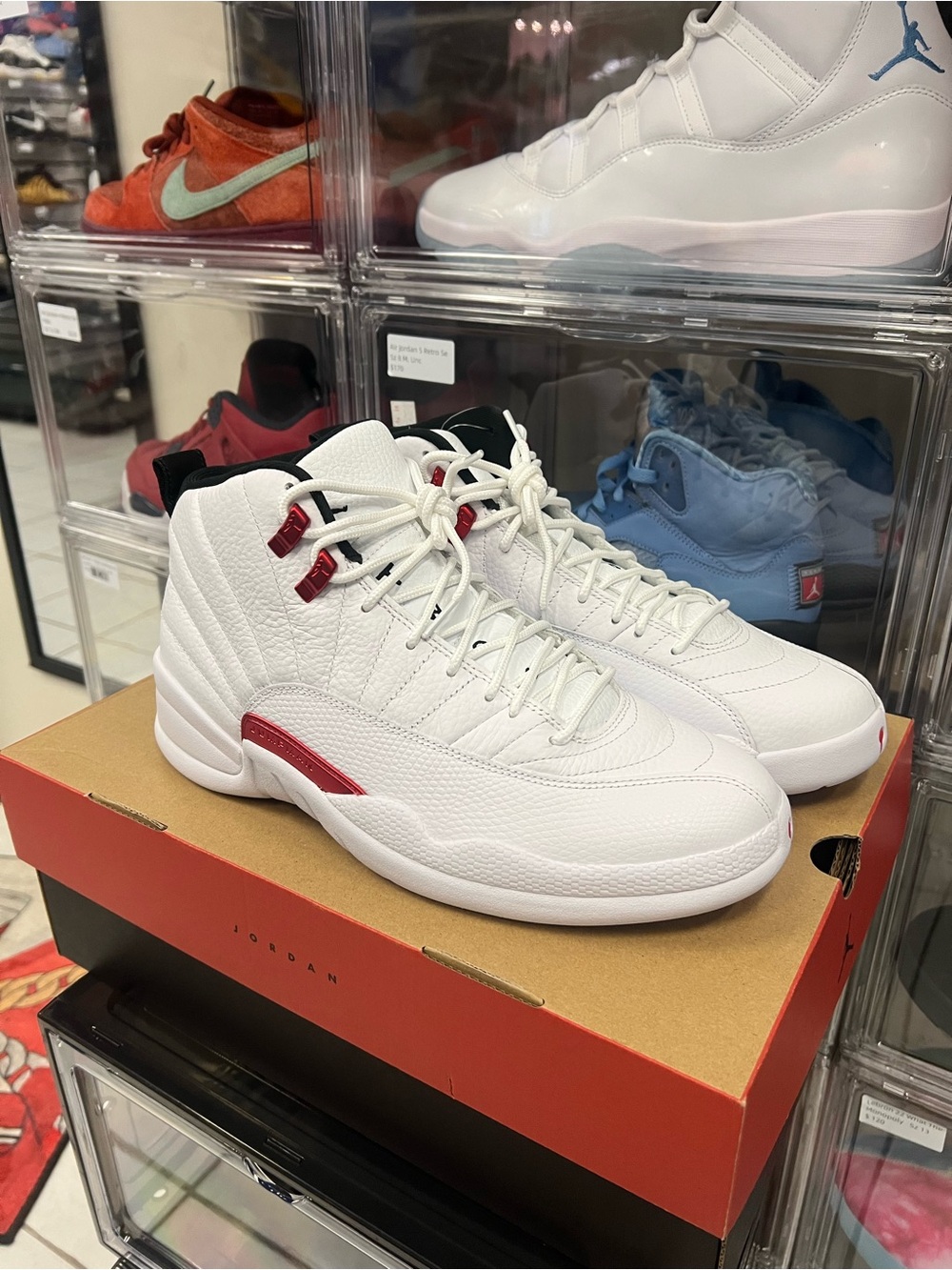 Air Jordan 12 Retro sneakers, specifically in the white and University Red TWIST
